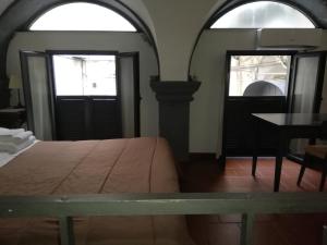 ナポリにあるNapulè Apartmentのベッドルーム1室(ベッド1台、テーブル、窓2つ付)