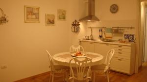a kitchen with a table and chairs in a kitchen at LA BARCHETTA suite in Orosei