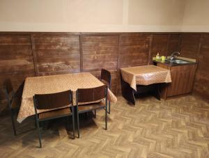 uma sala de jantar com duas mesas e um lavatório em Barbecue House em Vinnytsya
