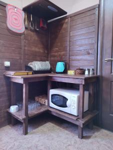 a microwave on a wooden shelf in a kitchen at Barbecue House in Vinnytsya