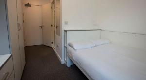 a large white bed in a small room at Private Bedrooms with Shared Kitchen at East Shore in St Andrews in St. Andrews +3 photos