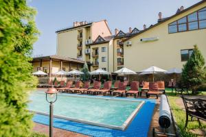 a hotel with a swimming pool with chairs and a building at Kyivska Russ Resort Medical&Spa in Skhidnitsa