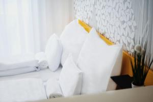 a room with white pillows on a white couch at RIVA Szeged in Szeged