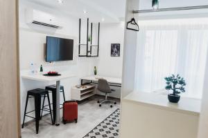 a small white room with a desk and a table at RIVA Szeged in Szeged