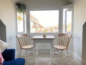 - une table et deux chaises dans une chambre avec fenêtre dans l'établissement Seaside Apartment, à Ramsgate