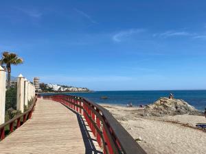 a wooden boardwalk leading to a beach with the ocean at Studio Pinar in Sitio de Calahonda