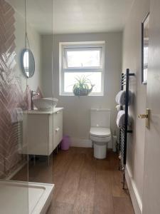 a bathroom with a toilet and a sink and a window at Seaside Apartment in Ramsgate