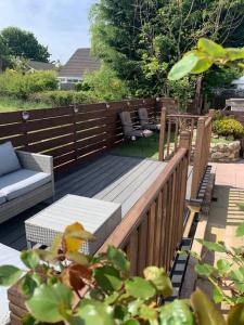 a wooden deck with a bench and a table and chairs at Mikes at Menai - Stylish & Spacious 3 bed house in Menai Bridge. in Menai Bridge