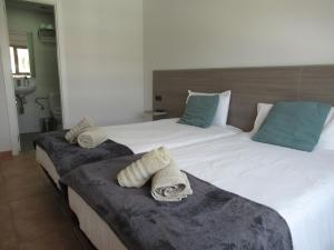 a bedroom with two beds with towels on them at NÁUTICO Suites, by Comfortable Luxury - Adults Only in Corralejo