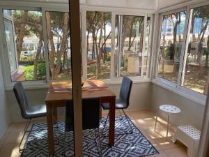 a table and chairs in a room with windows at Studio Pinar in Sitio de Calahonda
