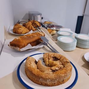 une table recouverte de assiettes de pain et d'un gâteau dans l'établissement Hotel Pixunte, à Policastro Bussentino