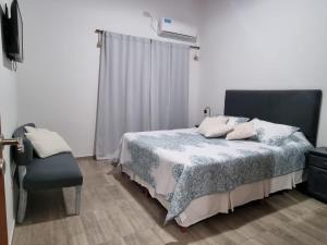 a bedroom with a bed and a chair at Departamento Sinsacate in Sinsacate