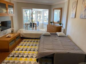 a bedroom with two beds and a desk and a tv at Studio Pinar in Sitio de Calahonda