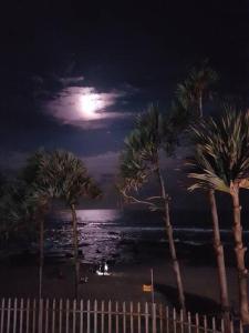 een volle maan boven een strand met palmbomen bij Beachfront Luxury - 2 Chaka's Place in Ballito