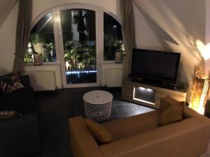 a living room with a couch and a flat screen tv at B&B wellness Sea Nat voor Naturisten in Oostduinkerke