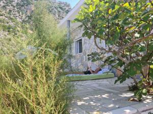 two people laying on a green couch in a house at Apartman Bačarije,Pag-Prizna in Seline