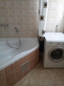 uma casa de banho com uma banheira ao lado de uma máquina de lavar roupa em Apartment Mihael - 4 persons em Vodnjan