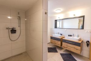 a bathroom with two sinks and a shower at Ferienwohnung Franz in Waltenhofen