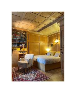 a bedroom with a bed and a chair at NONNA PINA Appartamento PUTTI in Padola