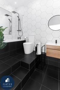 a black and white bathroom with a toilet and a sink at FLATZY - Victoria Street Apartment - Heart of City Centre in Liverpool