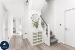 a white hallway with a staircase with a mirror at FLATZY - Victoria Street Apartment - Heart of City Centre in Liverpool