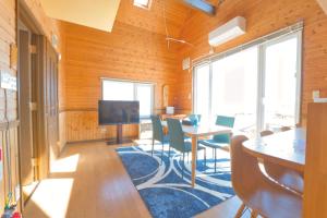 洞爺湖にあるLAKE TOYA Great view log cabinのテーブルと椅子、テレビが備わる客室です。