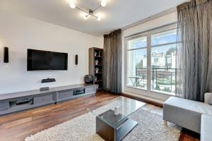salon z telewizorem i dużym oknem w obiekcie Dom & House - Apartments Parkur Sopot w mieście Sopot +37 zdjęć