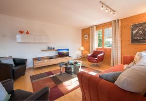 a living room with a couch and a table at Chalet Bergrose in Wengen