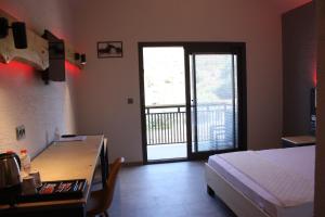 a bedroom with a bed and a desk and a door at Kosa Otel Çeşme in Cesme