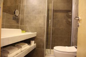 La salle de bains est pourvue d'un lavabo, de toilettes et d'une douche. dans l'établissement Kosa Otel Çeşme, à Çeşme