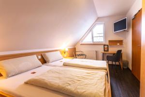 1 dormitorio con 2 camas, escritorio y ventana en Familiengasthof Schaller en Floß