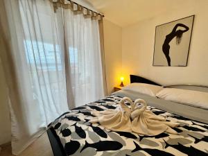 a bedroom with two swans towels on a bed at Apartments Stela in Gornji Karin