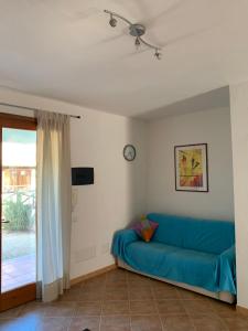 - un salon avec un canapé bleu et une fenêtre dans l'établissement Grazioso e confortevole appartamento a Chia, à Chia