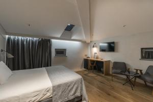 una camera d'albergo con letto, scrivania e sedia di Hotel Peteani a Labin