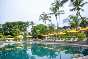a pool at the resort with chairs and umbrellas at Royal Beach Hôtel in Ambatoloaka