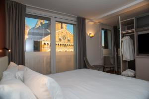 a hotel room with a bed and a view of a building at Padova Suites C20 in Padova