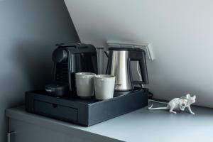 a cat walking on a shelf with a coffee maker and cups at Breeze Ameland in Hollum