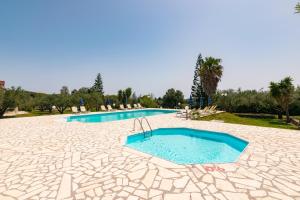 a large swimming pool with blue water in a resort at Lenna's Villas Zante in Vasilikos