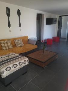 a living room with a couch and a table at Le Mas du Bijou Bleu in Puget-sur Argens