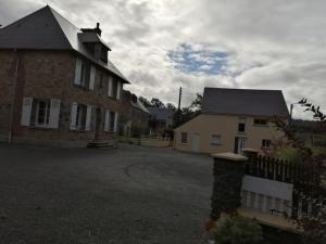 une grande maison en briques avec une clôture devant elle dans l'établissement Le Lutice, à Aunay-sur-Odon