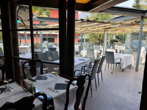 restauracja z białymi stołami i krzesłami oraz stolarką w obiekcie Garni degli Angioli w mieście Ascona
