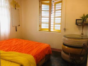 a room with a bed and a table and a window at Bảo Lộc Homestay in Bao Loc