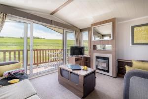 a living room with a fireplace and a television at COASTAL CARAVAN ELIE sleeps 6 in Elie