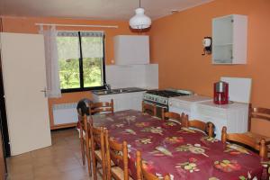 a kitchen with a table and a table and a stove at Villa du Bac in Chambon-sur-Lac