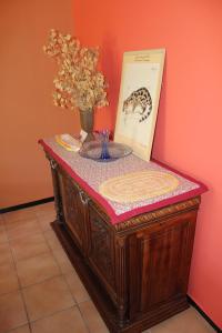 a table with a vase of flowers and a picture at Villa du Bac in Chambon-sur-Lac