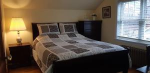 1 dormitorio con cama, lámpara y ventana en Comfy Stay - Close to Everything en Halifax