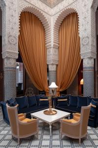Riad Fes - Relais & Châteaux في فاس: غرفة طعام مع طاولة وكراسي