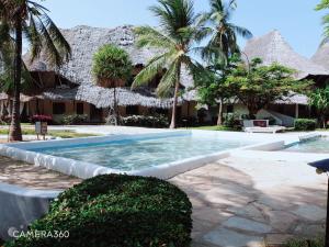 a swimming pool in front of a resort at Diwani Cottage in Malindi