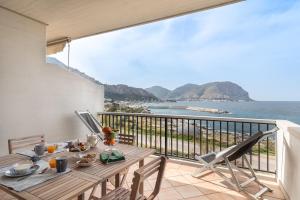 ein Tisch auf einem Balkon mit Blick auf das Meer in der Unterkunft Mondello in Terrazza by DomuSicily in Mondello