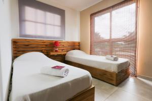 2 camas en una habitación con ventana en Apart Hotel Las Violetas en Candelaria